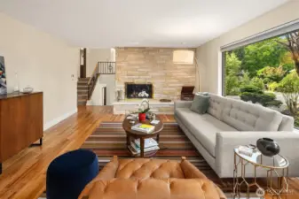 A warm and welcoming living room anchored by a mid-century style fireplace and oak hardwood floors. Stairway with easy access to the 4 bedrooms and hallway bathroom.