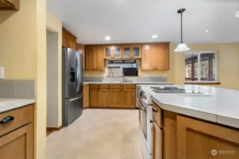 Tile counter on island with additional cabinet and drawer space. Have you noticed how many handy electrical outlets there are?