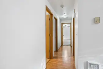 Hallway leads to three bedrooms and two full bathrooms.