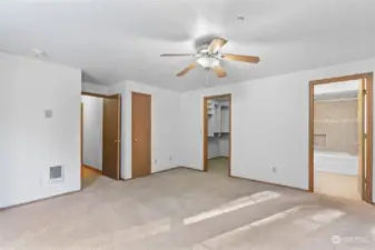 Ceiling fan in Primary Suite, the only room with carpet, completed with private bathroom and walk-in closet.