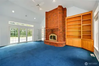 The wonderful family room has sliding doors onto the deck, a wood-burning fireplace, and lovely built-ins