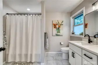 Primary bath with tub/shower unit leading to large walk-in closet on left.