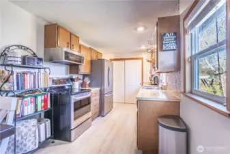 opened up galley kitchen with new flooring, trim and paint