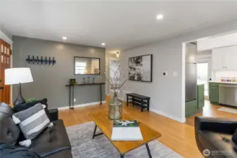 Bright living room featuring large windows,  recessed lighting, and a welcoming layout  for relaxing or entertaining.