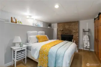 Cozy lower-level spare room featuring a  warm wood-burning fireplace, perfect for  guests or relaxation.