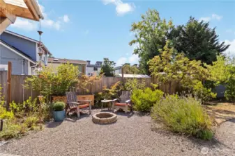 This backyard soace offers a cozy fire pit and  seating area