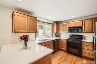 TASTEFUL KITCHEN WITH QUARTZ COUNTERS, PLENTY OF CABINET SPACE & EASE OF ACCESS TO DINING RM.