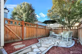 View of your side yard with recently upgraded and expanded sitting area with beautiful stone.