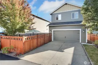 Rear view of property, alley entrance, side yard, driveway parking for you and your guests, home is handsomely landscaped front and back!