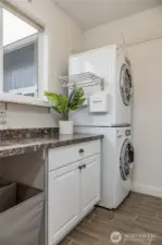 Laundry room maximizes space with stackable washer/dryer that stay with the home