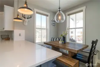 View of dining room with built in bench and decorative lighting.