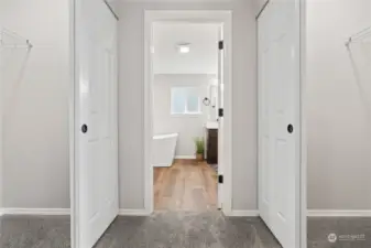 Primary Bedroom w/Double Walk-In Closets on either side of the hallway leading to the En Suite Bath.