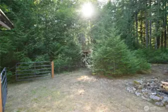 Gated entrance to fenced off back yard and wood storage {in background}