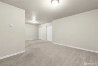 Ground level, daylight basement 4th.  The home has a two car garage that leads onto the ground level with hallway to full bathroom, storage closet and this 4th bedroom which is a rec room sized room with two windows and quadruple wide closets!  There is an over head outlet for plugging in a projector screen