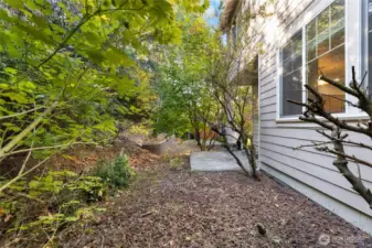 Backyard with covered patio.  There is no lawn to mow here as the flower bed is mostly of decorative lava rock (pebbles)