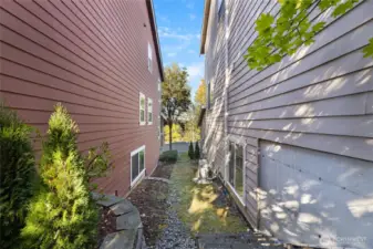 From the side of the yard looking towards the west, notice the heat pump on the side of the house.  There are stairs leading from the patio to the side yard
