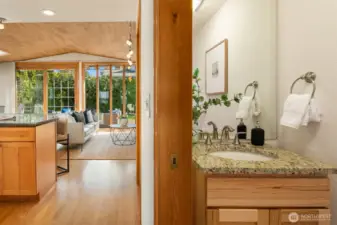 A charming powder room just off the family room, featuring warm wood accents and classic fixtures — a thoughtfully positioned and tastefully finished space that complements the home's natural, inviting aesthetic.