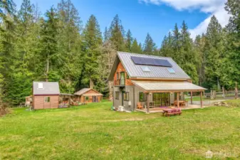 A view of all three structures. The main residence, post and beam studio, and blue pine cabin nicely set across the property.