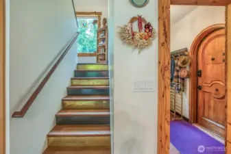 A light-filled staircase leads to the upper level with two bedrooms and a bath with washer and dryer, enhanced by a picture window at the landing.