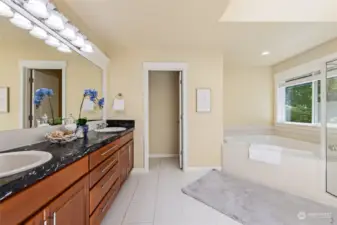 Luxurious primary bath with dual vanity, soaking tub, shower and toilet closet.