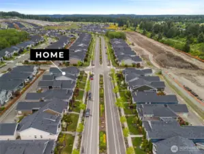 The aerial view showcases the home’s position within a beautifully designed neighborhood featuring tree-lined streets, landscaped sidewalks, and easy access to walking trails and parks. This exceptional location offers not only comfort and convenience but also a strong sense of community and lifestyle.
