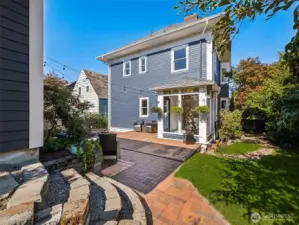 Mature landscaping that blooms all year, with a brick winding path. Porch with water feature and twinkle lights.