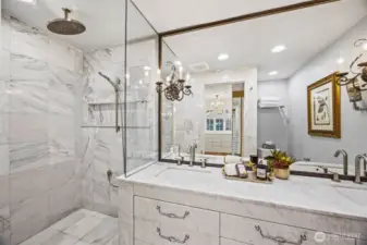 Absolute stunning primary bathroom with custom vanity built in place and entirely clad in Bianco Carrara polished marble design. Heated floors and Grecian white marble in the shower.