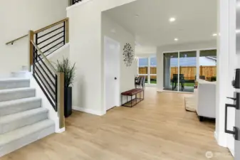 A soaring entryway offers a dramatic first impression, drawing your eye straight through to the lush backyard.