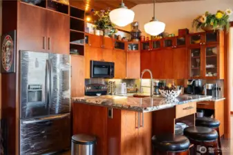 The kitchen has all stainless steel appliances and incredible hand crafted cabinets. The custom refrigerator matches that of the kickplates on the stairways.