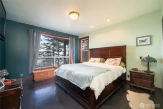 The primary bedroom is very spacious and has a window seat-style built-in dresser to take in the tranquil views.