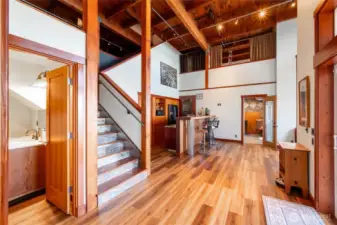Looking at the lower level with the full bath to the left of the stairs and the steam room at the far end. The kitchen and recreational room is positioned to the center.
