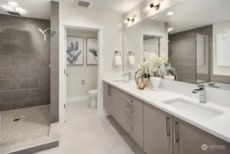 Well-appointed 5-piece primary bath with heated floors, Delta Ara fixtures and quartz countertops.