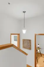 Vaulted ceilings and half walls, create light in stairwell and unite all three levels