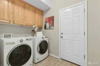 The laundry room has storage and functions as a mud room connecting the home to the 3-car garage.