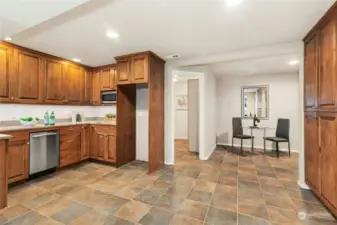 The lower-level kitchenette has a large sink, dishwasher, microwave, fridge space, and amazing storage.