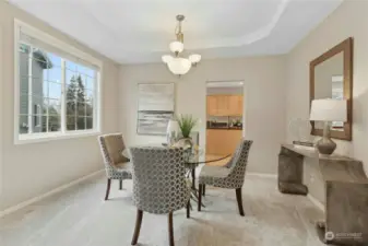 The dining room is adjacent to the kitchen and offers a stylish trayed ceiling.