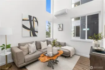 An architectural dream, this space combines sleek design with warm, inviting elements. The open layout, featuring a glass-paneled staircase and soaring ceilings, bathes the living area in natural light, creating an inspiring canvas for your lifestyle. (Photos are of staged model).