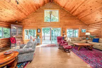 The stunning great room has soaring ceilings, expansive picture windows & a fabulous deck overlooking the water.