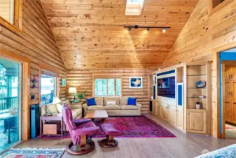 This casually elegant great room has a built-in entertainments center, vinyl plank floors, skylights & water views.