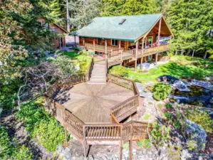 A bird's eve view of the main house, incredible decking, all surrounded by lush gardens and water features.