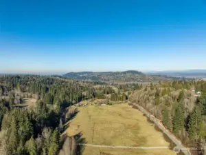 Expansive property with sweeping views of Lord's Hill and the surrounding evergreen landscape. Quiet country road access with open pastureland framed by a forested creek to the West, a gorgeous fence to the South, and the country road it abuts to the East.