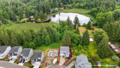 aerial view of the home and lake behind it. The area behind the home is protected land & cannot be built on!