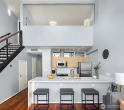 Modern kitchen features a 12 ft island with quartz countertops and breakfast bar seating
