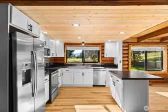Updated kitchen with soft-close cabinetry that pairs light, bright design elements against the natural log walls, creating a fresh yet cozy contrast.