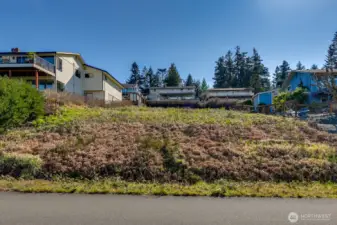Standing below the lot on W Flintstone Drive looking back at the lot. The slope is perfect for a daylight basement rambler.