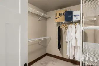 A large walk-in closet provides ample hanging space and shelving.