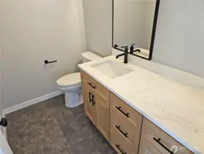 Ample vanity counter space and storage cabinetry in 2nd bath