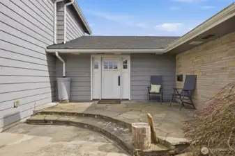 The front entry is welcoming (even in the winter time) with its flagstone walkway and sitting area, and accent wall.
