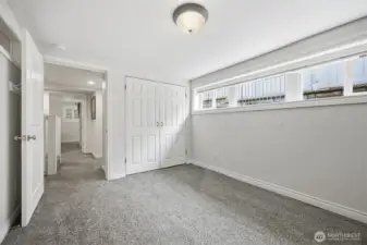 This is the second bed room looking toward the primary suite with the stairway in between.
