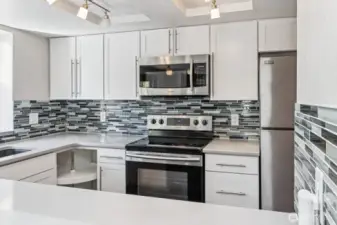 A modern tile backsplash complements the gorgeous quartz countertops.